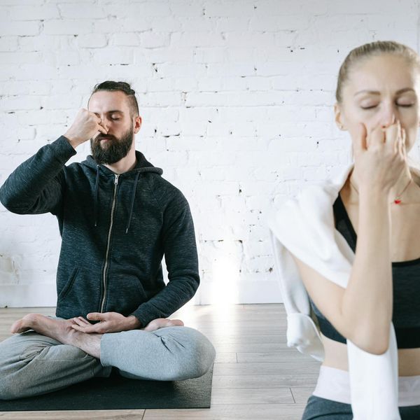 Woman practicing calm breathing meditation in a bright, peaceful room.